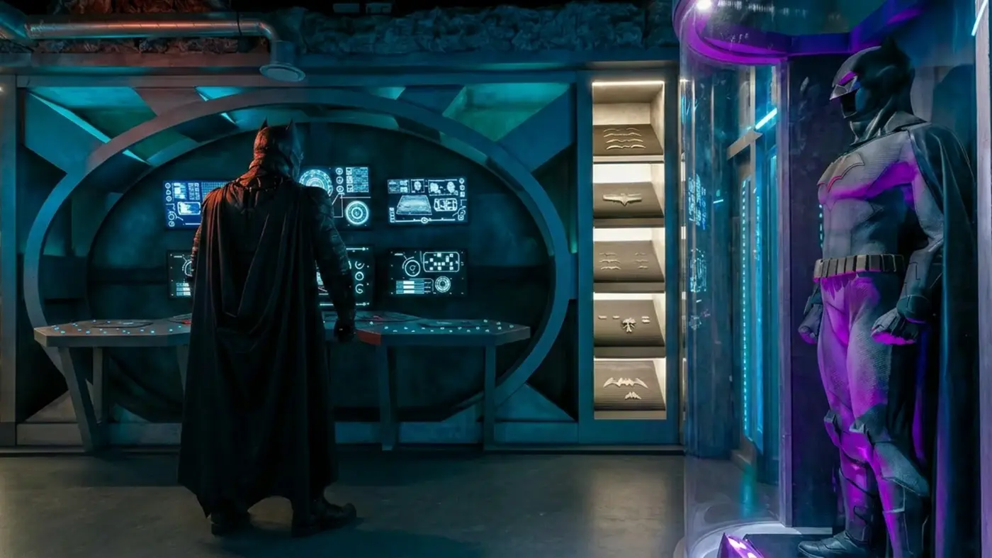 Le décor de la Batcave, avec ses écrans et le costume de Batman sous vitrine